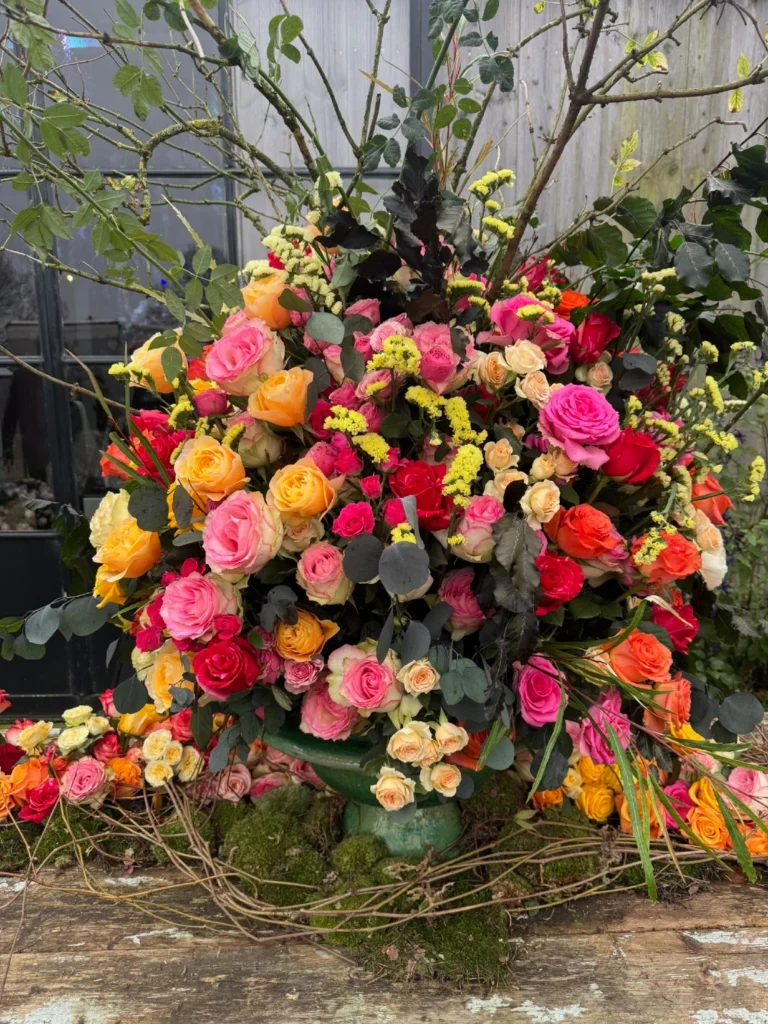 Vibrant outdoor floral arrangement featuring multicolored roses and branches at Aalsmeer flower trade show